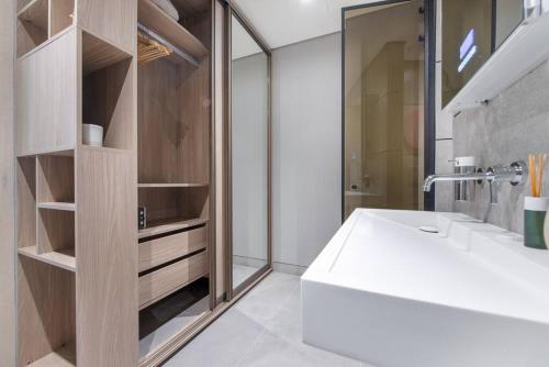 a bathroom with a white tub and a sink at Modern flat with KING SIZE bed and HIGH SPEED Wifi in Dubai
