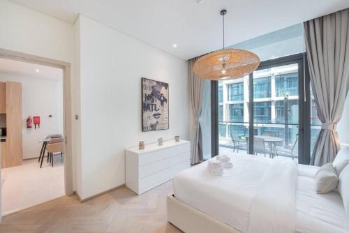 a white bedroom with a large bed and a dining room at Modern flat with KING SIZE bed and HIGH SPEED Wifi in Dubai