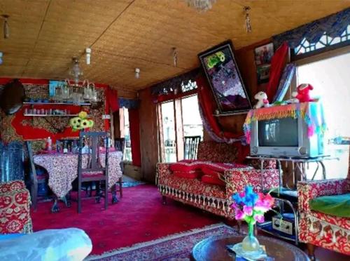 uma sala de estar cheia de mobiliário e uma televisão em H.B.victoria Garden em Srinagar