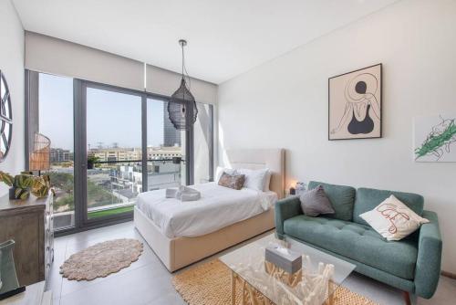 a bedroom with a bed and a couch and a window at Fantastic Studio resort style facilities - OFFER in Dubai