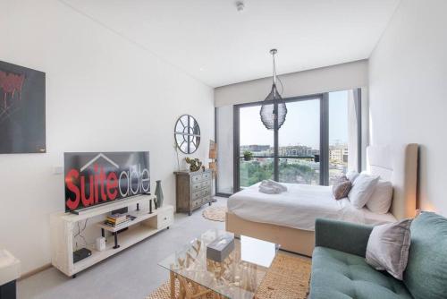 a bedroom with a bed and a tv and a couch at Fantastic Studio resort style facilities - OFFER in Dubai