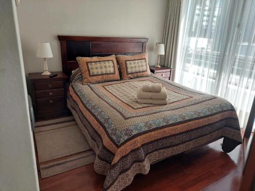 a bedroom with a bed with two towels on it at Austral Rentahome Santa Beatriz in Santiago