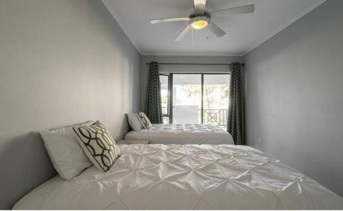 a bedroom with two beds and a ceiling fan at Luxury on 1B Patricia in Ballito