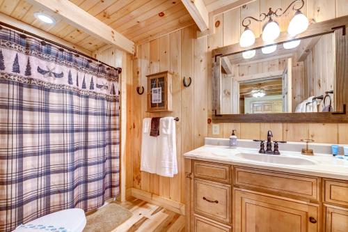 uma casa de banho com um lavatório, um WC e um espelho. em Waynesville Cabin with Covered Deck and Fire Pit! em Lake Junaluska