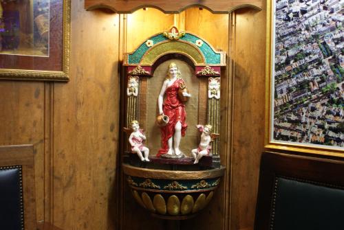 a statue of a woman with two children in a clock at Nadia Hotel in Amsterdam