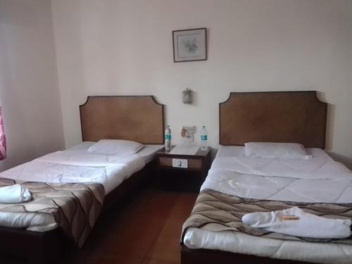 two twin beds in a room with at Hotel Indsurya in Dibrugarh