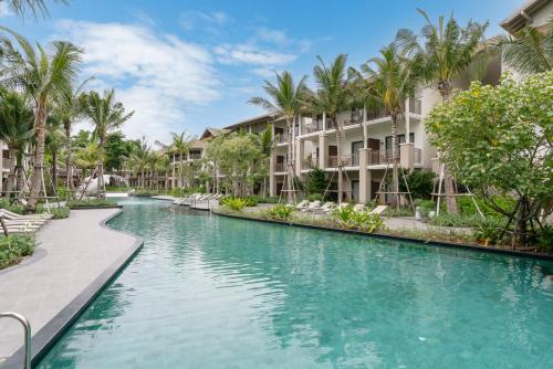 a pool at a resort with palm trees and condos at Holiday Inn Resort Samui Bophut Beach by IHG in Bophut 
