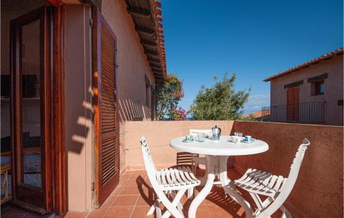 - Balcón con mesa blanca y sillas en Cozy Apartment In Costa Paradiso, en Costa Paradiso