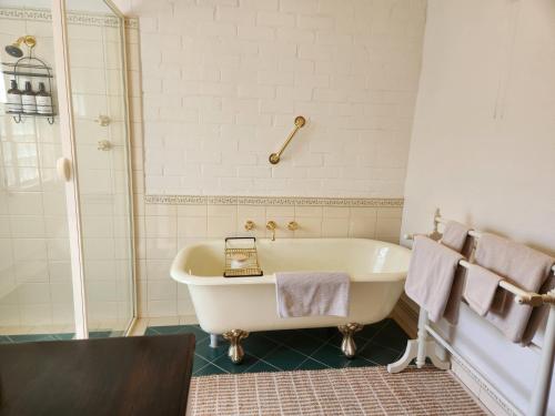 une salle de bain avec baignoire et douche dans l'établissement Marananga Cottages, à Marananga