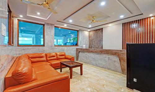 a living room with a leather couch and a tv at Itsy Hotels Elite Inn in Chennai