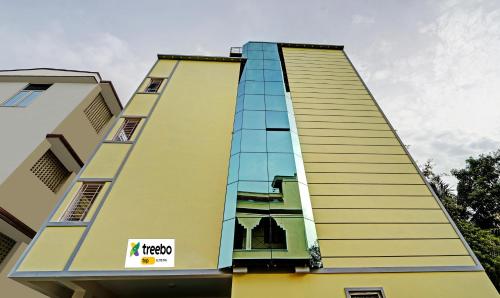un edificio alto amarillo con un cartel en él en Itsy By Treebo - Elite Inn, en Chennai