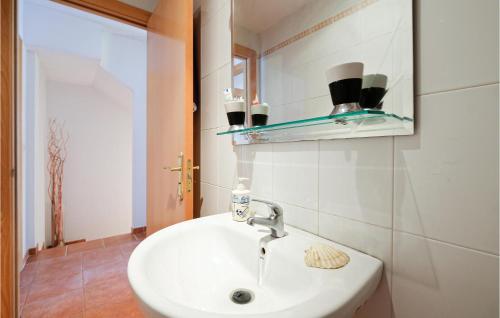 ein Badezimmer mit einem weißen Waschbecken und einem Spiegel in der Unterkunft 3 Bedroom Awesome Home In La Algaba in La Algaba
