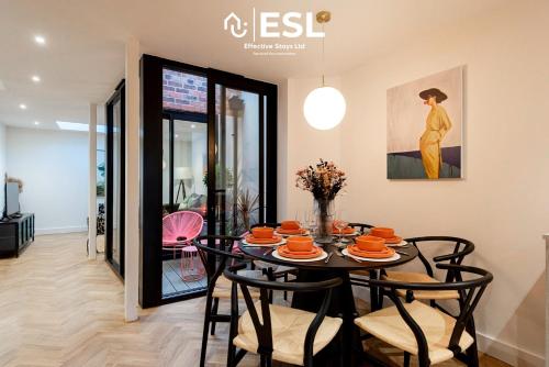 un comedor con una mesa con platos naranjas. en Contemporary Townhouse - Free Parking - Central Shrewsbury, en Shrewsbury