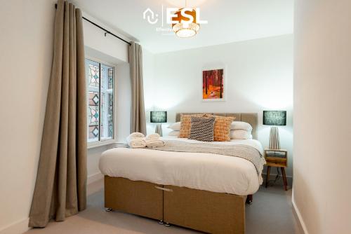 un dormitorio con una cama y una ventana en Contemporary Townhouse - Free Parking - Central Shrewsbury, en Shrewsbury
