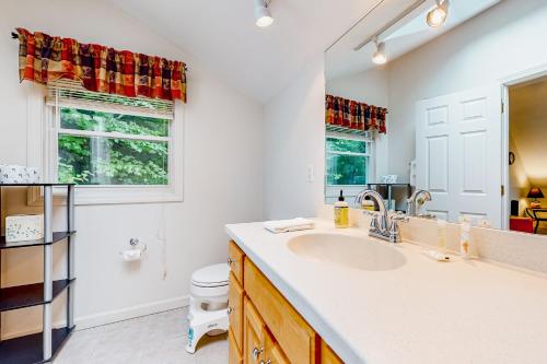 a bathroom with a sink and a toilet and a mirror at Mountain Retreat in Conway