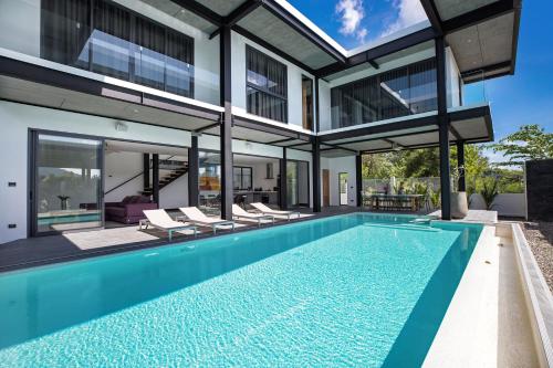 an exterior view of a house with a swimming pool at Loft-Style Hyper Modern 4Br Villa Sunset garden 6 with 12x5m Salt Pool in Rawai Beach