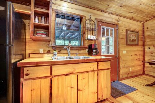 a kitchen with a sink in a wooden cabin at Private Broken Bow Cabin with Hot Tub and Gazebo! in Broken Bow