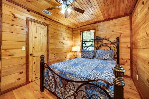 a bedroom with a bed in a log cabin at Private Broken Bow Cabin with Hot Tub and Gazebo! in Broken Bow