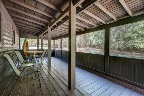 a room with a table and chairs on a deck at Private Broken Bow Cabin with Hot Tub and Gazebo! in Broken Bow