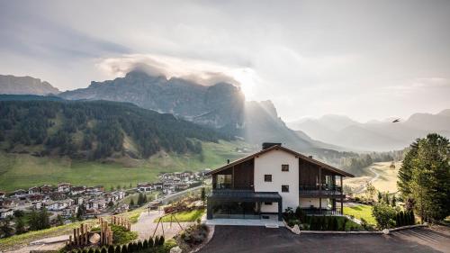 a house on a hill with mountains in the background at Surega - Idyllic Farmhouse in San Cassiano