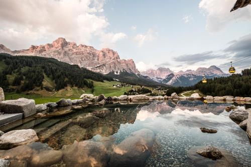 a lake in the mountains with a cable car at Surega - Idyllic Farmhouse in San Cassiano