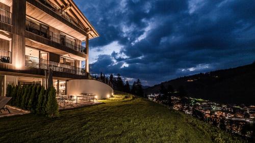 a building with a view of a city at night at Surega - Idyllic Farmhouse in San Cassiano