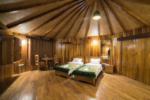 Rinchingpong的住宿－Yangsum Heritage Farm，一间设有两张床的房间和一张帐篷内的桌子