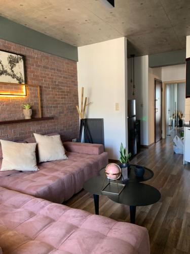 a living room with a couch and a brick wall at The Grey Apartments in Volos