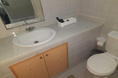 uma casa de banho com um lavatório, um WC e um espelho. em OYO 142 Al Sharqiya Sands Hotel em Ibrā