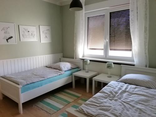 1 Schlafzimmer mit 2 Betten und 2 Fenstern in der Unterkunft Ferienwohnung am Keramikatelier in Bitterfeld