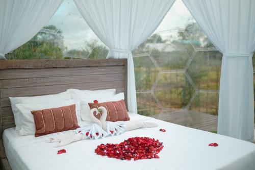 a bed with red roses and a doll on it at Skyspace Villas Bali in Dalung
