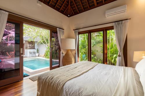 a bedroom with a large bed and a pool at Bingin Castaways in Uluwatu