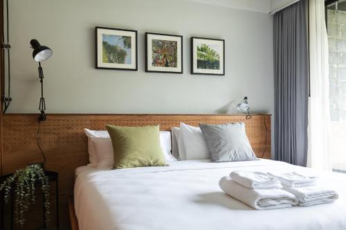 a bedroom with a white bed with towels on it at GalileOasis Boutique Hotel in Bangkok