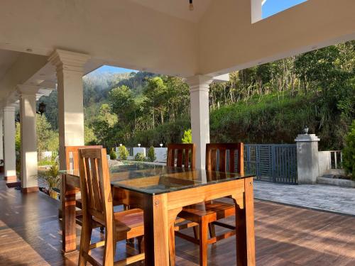 - une table à manger et des chaises sur la terrasse dans l'établissement Titha Service Villa, à Santhanpara