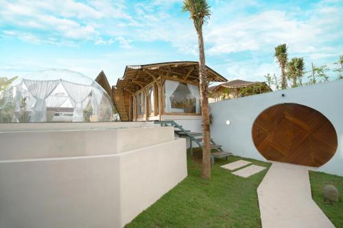 a house with a wooden door and a palm tree at Skyspace Villas Bali in Dalung