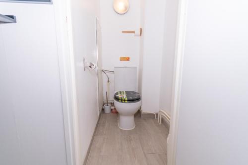 a small bathroom with a toilet with a black seat at Private & Comfortable Apartments in Puttelange-aux-Lacs
