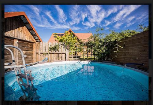 a large swimming pool in a backyard with a wooden fence at Borówkowy Domek Kłoda Duża in Zalesie