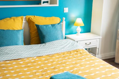 a bedroom with a bed with blue walls and a lamp at Private & Comfortable Apartments in Puttelange-aux-Lacs