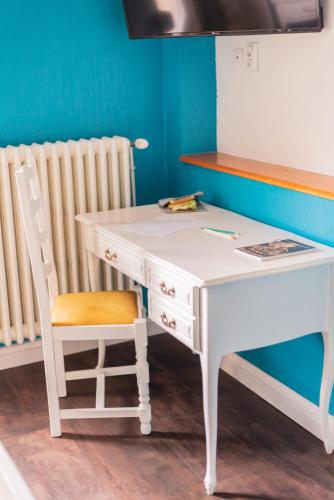a white desk with a chair next to a radiator at Private & Comfortable Apartments in Puttelange-aux-Lacs