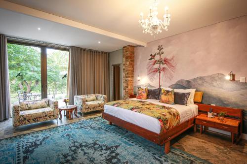 a bedroom with a bed and a chandelier at Droombos Boutique Hotel in Windhoek