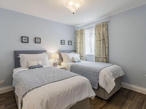 a bedroom with two beds and a window at Apartment 18, Burgh Island Causeway in Kingsbridge