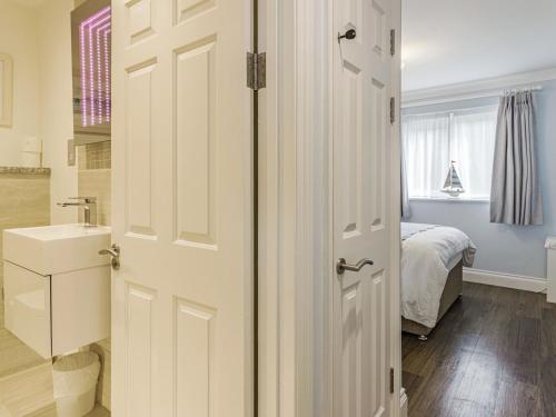 a bathroom with a door leading to a bedroom at Apartment 18, Burgh Island Causeway in Kingsbridge