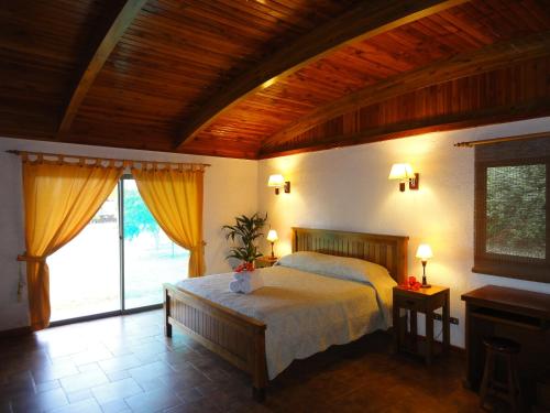 ein Schlafzimmer mit einem Bett und einer Holzdecke in der Unterkunft Heva Eco Lodge in Hanga Roa