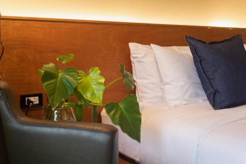 a bedroom with a bed with a pillow and a chair at GalileOasis Boutique Hotel in Bangkok