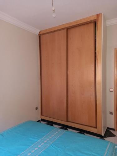 a large wooden closet in a room with a bed at APPARTEMENT ZENITH in Casablanca