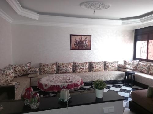 a living room with a couch and a table at APPARTEMENT ZENITH in Casablanca