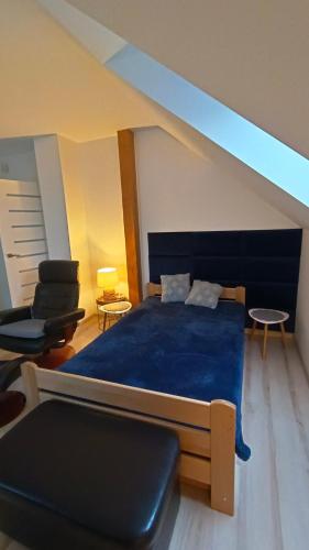 a bedroom with a blue bed and a chair at Komfortowe Noclegi in Szałsza