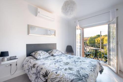 een slaapkamer met een bed en een groot raam bij Maison de ville à proximité du centre historique in Villeneuve-lès-Avignon