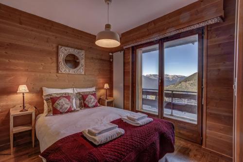 a bedroom with a bed with a large window at Appartement Bellevue 527 in La Tzoumaz