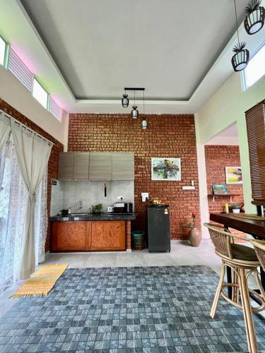 a large room with a kitchen with a brick wall at Adagaya Villa - Villa With Private Pool, Without Pool in Pantai Cenang